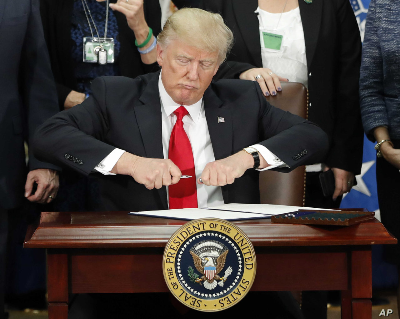 DAY 6 - In this Jan. 25, 2017, file photo, President Donald Trump takes the cap off a pen before signing executive order for immigration actions to build border wall during a visit to the Homeland Security Department in Washington. (AP Photo/Pablo Martinez Monsivais, File)